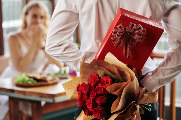 man-hiding-bouquet-roses-giftbox-his-back-as-birthday-present-girlfriend_274689-16872